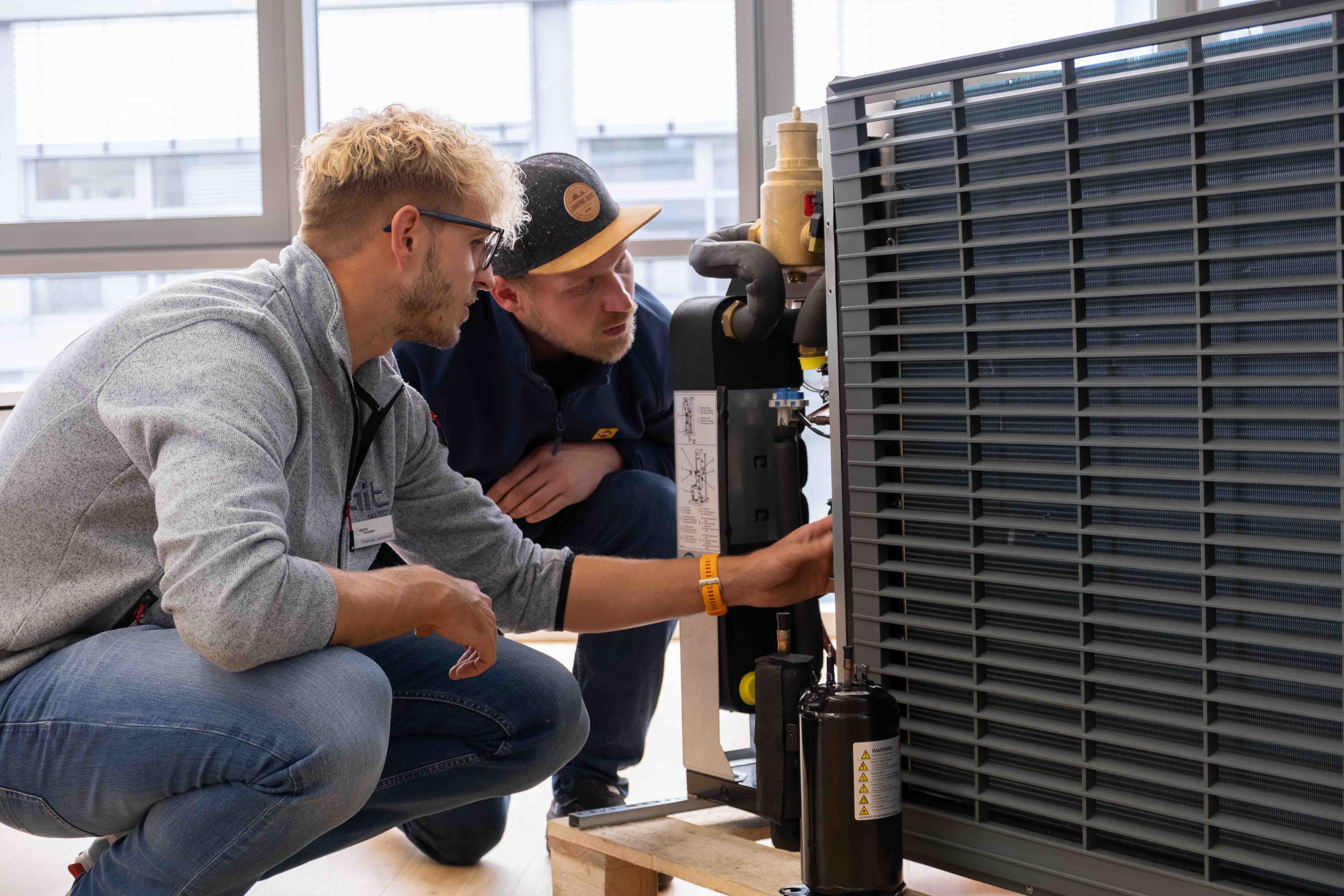 Zwei Personen prüfen eine Wärmepumpe