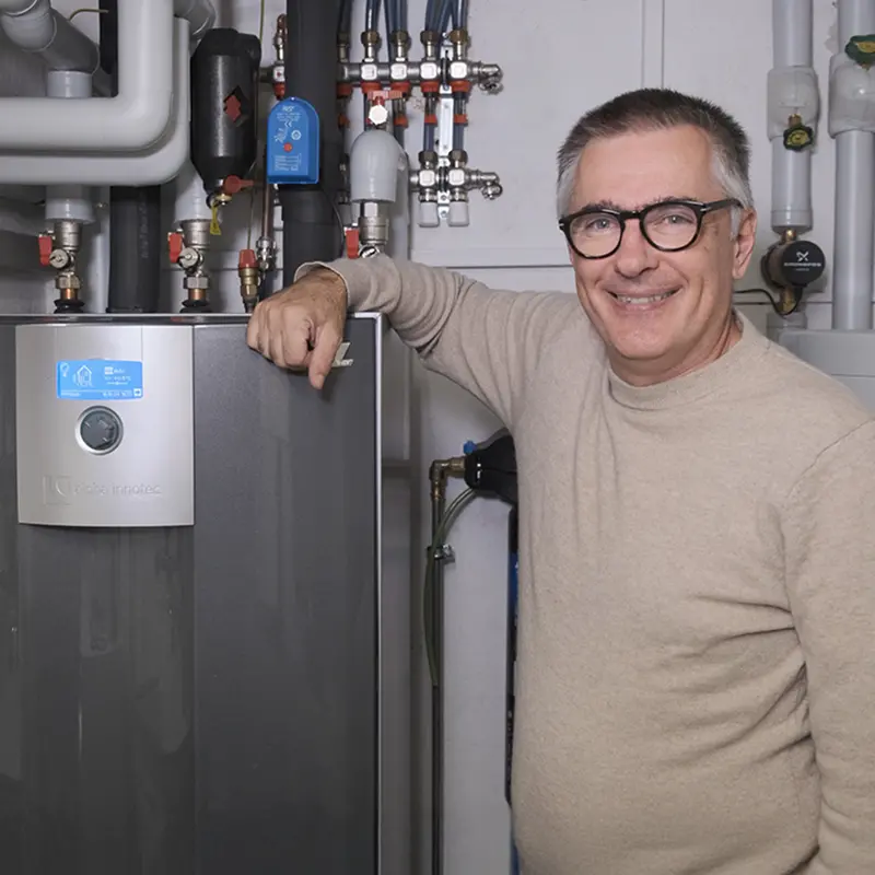 Bauherr steht vor seiner Wärmepumpe