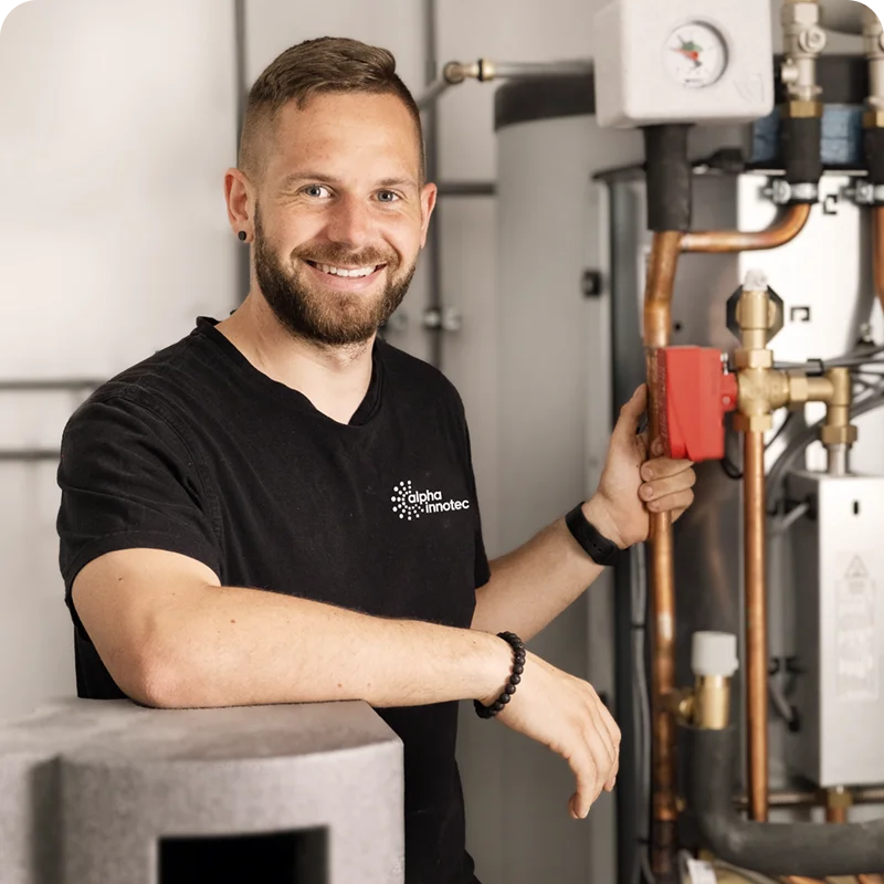 Ein alpha innotec Techniker wartet eine Wärmepumpe