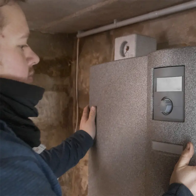 Ein Installateur wartet eine Wärmepumpe