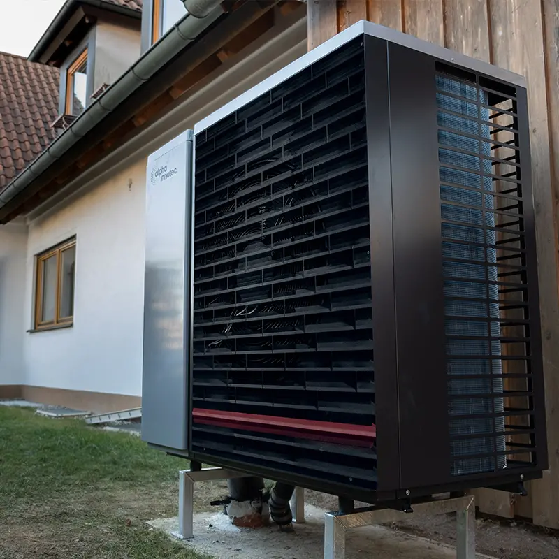 Eine Wärmepumpe vor einem Mehrfamilienhaus