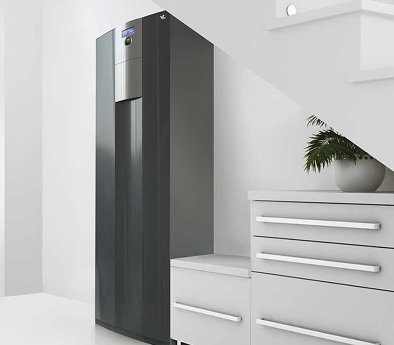 The brine/water heat pump WZSV is installed indoors, under the stairs with some cupboards on its right side.
