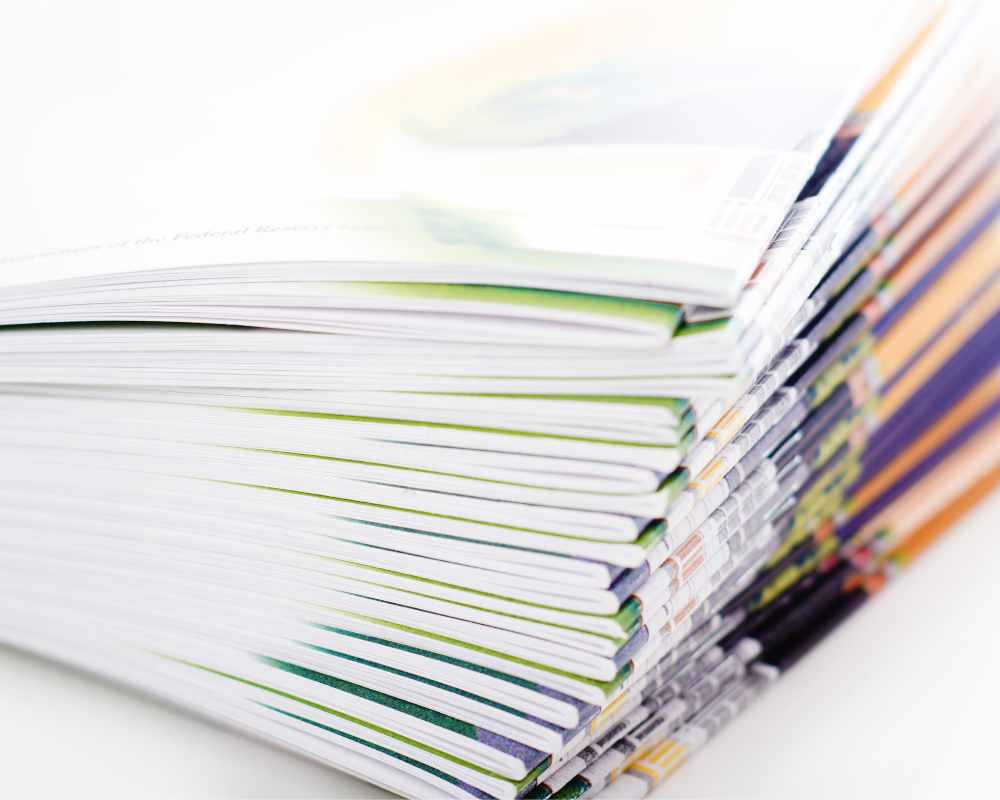 It shows the close-up of one corner of a stack of colorful brochures.
