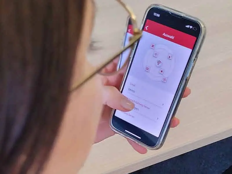 Frau tippt auf Handy in der alpha App